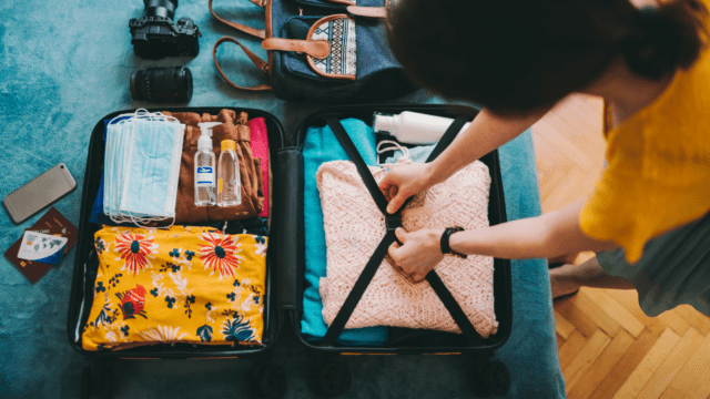 Une femme prépare ses valises pour partir en vacances