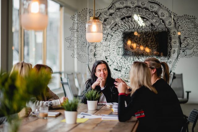 Femmes qui discutent autour d'une table lors d'un événement L'effet A