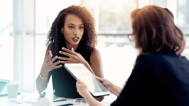 Femme présentant son projet à une personne à l'écoute